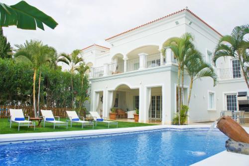 阿德耶Villas Espléndida的一座别墅,设有游泳池和棕榈树