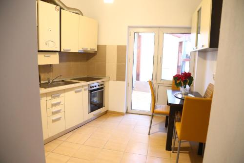 锡比乌Dioniss Apartment的厨房配有白色橱柜和桌子,厨房
