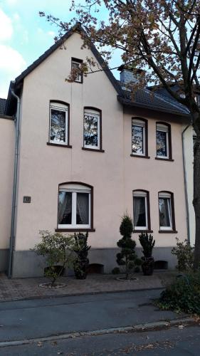 格拉德贝克Ferienwohnung Gladbeck-Rohde的街上的白色房屋,设有黑窗