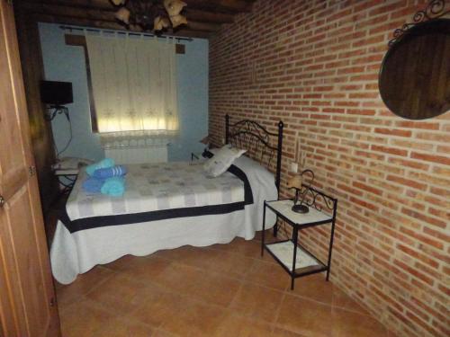 NavasfríasUn Rincón Salmantino的一间卧室设有一张床和砖墙