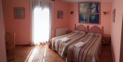 PeralejosHostal La Vega的一间卧室设有一张床和一个窗口