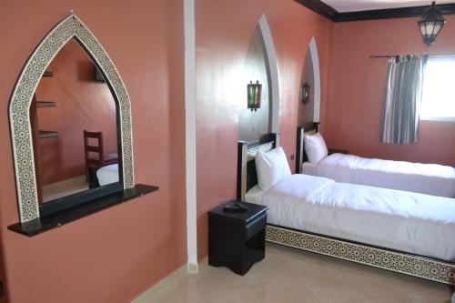 达赫拉Inyan Dakhla Hotel的一间卧室配有两张床和镜子