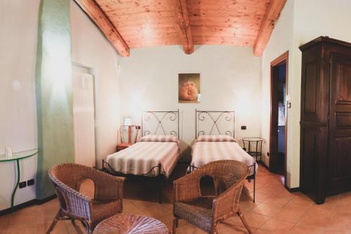 福萨诺Agriturismo Fiori di Zucca的配有两张床铺的房间,配有椅子和桌子