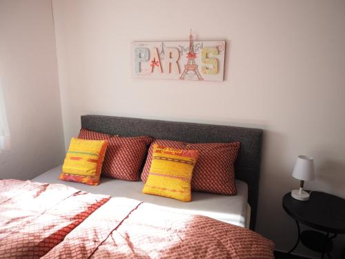 格罗森塞巴赫2-Zimmer-Whg im Souterrain mit neuer Sauna的一间卧室配有带色彩缤纷枕头的床。