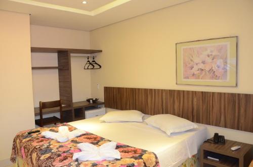 福塔莱萨Ara Mar Praia Hotel的一间卧室,床上有两朵白色的花