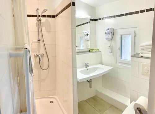 圣伊波利特迪福尔Logis Auberge Cigaloise的带淋浴和盥洗盆的白色浴室