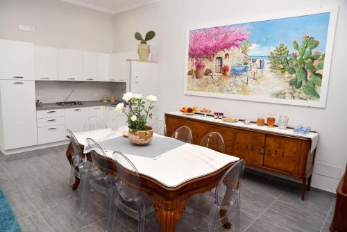 兰佩杜萨DolceLina Home的厨房配有桌子,墙上挂有绘画作品