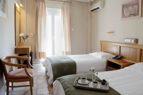 塞萨洛尼基佩拉酒店的酒店客房,配有两张床和椅子