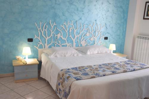 圣贝内代托-德尔特龙托Residence Acquamarina的一间卧室设有一张蓝色墙壁的大床