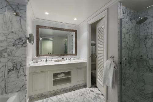 瓦克拉Fairmont Orchid Gold Experience的一间带水槽、镜子和淋浴的浴室