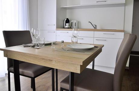 Rietheim-Weilheimrent-my-apartment的厨房里配有带酒杯的木桌
