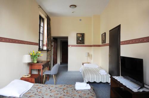 克拉科夫冬卡西米旅馆的酒店客房配有一张床、一张书桌和一台电视。