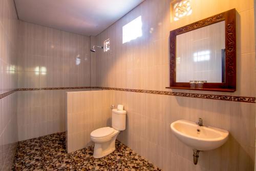 乌布乌布文斯住宿加早餐旅馆的一间带卫生间、水槽和镜子的浴室