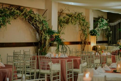 塔比拉兰雷纳纽黑文花园酒店的宴会厅配有桌椅和鲜花