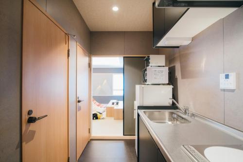 金泽Ishizue TABI-NE的一间带水槽和冰箱的小厨房