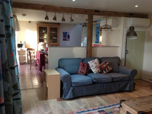 Kirkton of LargoCutty Sark Cottage的一间带蓝色沙发的客厅和一间厨房
