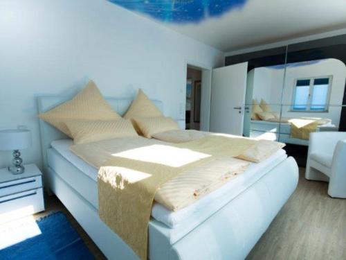 BurtenbachFerienparadies Amadeus的卧室配有一张白色大床和镜子