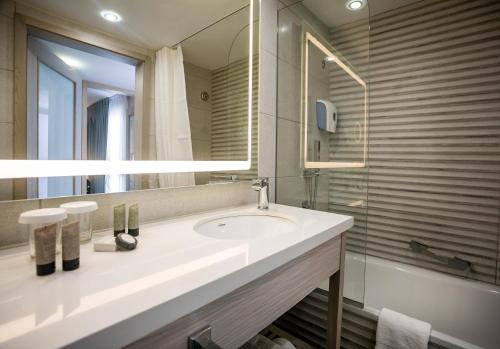 埃拉特艾斯炊酒店的浴室配有盥洗盆、镜子和浴缸