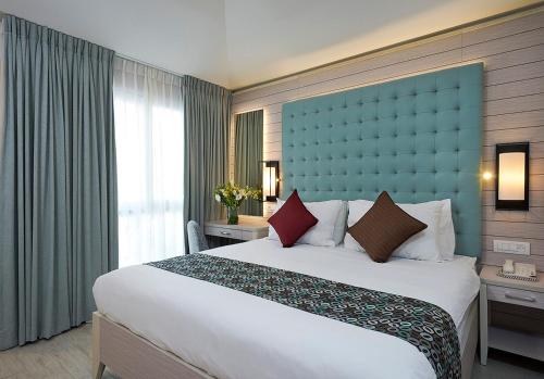 埃拉特艾斯炊酒店的一间卧室配有一张大床和蓝色床头板