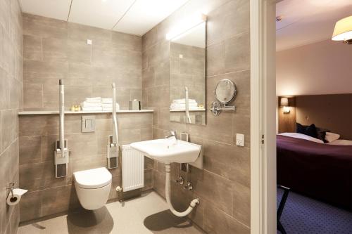 Stouby维杰尔福德会议酒店的一间带水槽和卫生间的浴室以及一张床