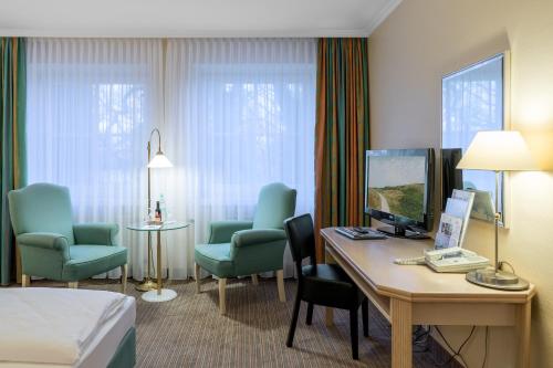 埃姆登阿普斯达尔布姆公园酒店的酒店客房,配有一张床、一张桌子和椅子
