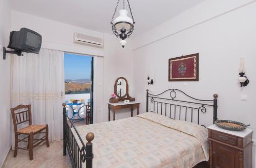 阿斯提帕莱亚镇Yalos rooms的一间卧室设有一张床、一台电视和一个窗口。