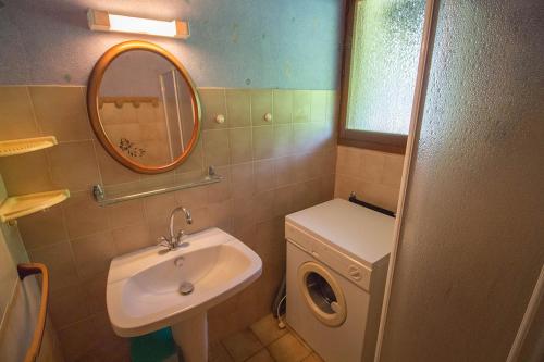欧雷扬Hameau 516的一间带水槽和镜子的浴室以及一台洗衣机
