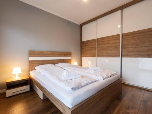 科沃布热格VacationClub – Bliżej Morza Apartament 98的一间卧室配有一张带白色床单的大床