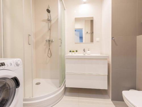 科沃布热格VacationClub – Bliżej Morza Apartament 98的带淋浴水槽和洗衣机的浴室