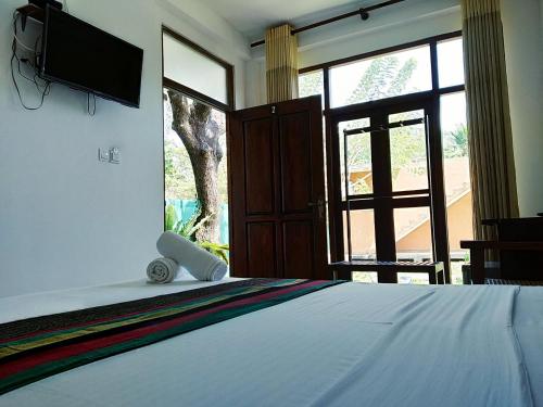 丹不拉Thammenna Eco Cabins的卧室配有一张床铺,墙上配有电视
