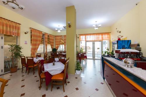都拉斯Hotel Vila Misiri的餐厅内带桌椅的用餐室