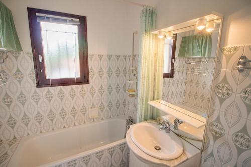 米尼赞海滩Les Genêts的浴室配有盥洗盆、卫生间和浴缸。