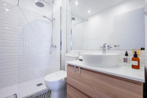 法鲁Ria Beach House的白色的浴室设有水槽和卫生间。