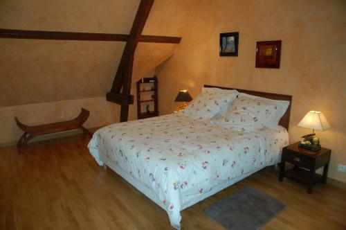 Francueil罂粟花住宿加早餐酒店的一间卧室配有一张床,铺有木地板