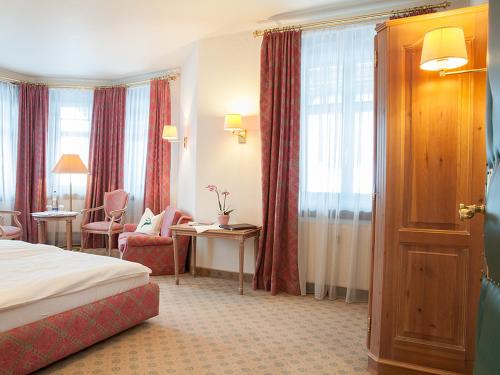 泰根塞Gästehaus Florian的酒店客房带一张床、一张桌子和椅子