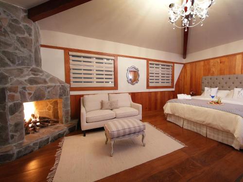 下博克特芬卡莱里达咖啡种植园和精品酒店的一间卧室设有壁炉、一张床和一张沙发