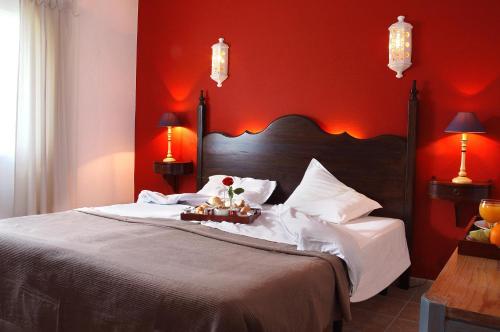 珀彻斯Casa Bela Moura, Boutique Hotel & Wine的一间卧室设有一张带红色墙壁的大床