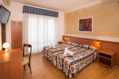 利多迪耶索罗Hotel Antille e Azzorre的配有一张床和一张书桌的酒店客房