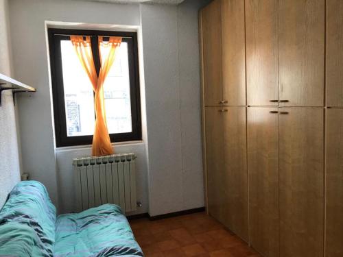 皮亚扎托雷Il Capriolo的卧室设有窗户,窗户前设有沙发