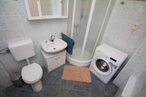 巴拉顿菲兹弗Holiday home in Balatonfűzfo 35646的浴室配有卫生间水槽和洗衣机。