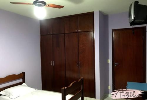 巴雷图斯Casa di Angeli的一间卧室配有一张床、木制橱柜和吊扇。