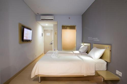 雅加达雅加达法玛瓦蒂凯利亚酒店的卧室配有一张白色大床和电视。