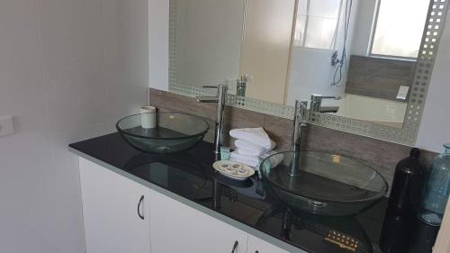 赫维湾赫维湾桑塔琳娜酒店的浴室在柜台上设有两个玻璃水槽