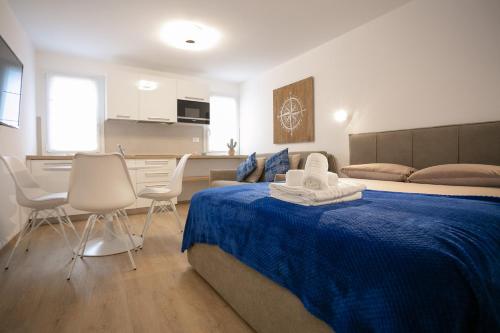 基奥贾Casa Azzurra的一间卧室配有一张带蓝色毯子和椅子的床