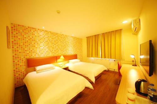 郑州如家快捷酒店郑州黄河路省人民医院店的酒店客房配有两张床和一张书桌