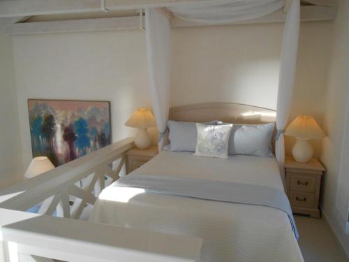 伊兹拉HydraVista (Coral)的卧室配有白色的床和两盏灯。