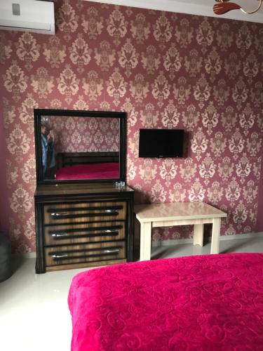 科布列季Guest house BAGRATIONI的一间卧室配有一张床、镜子和一张桌子