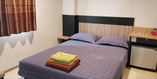 雅加达智能之家公寓的一间卧室配有一张带两个枕头的紫色床