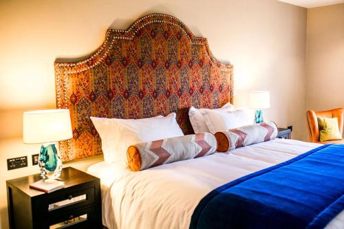 埃文河畔斯特拉特福Baraset Barn Hotel的一间卧室配有一张大床和大床头板