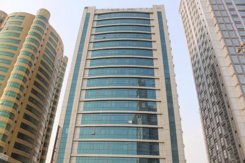 富查伊拉Clifton International Hotel的两座高大的建筑,带有玻璃窗户